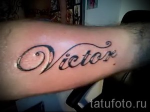 Фото татуировки с надписью 'Victor', выполненной черными чернилами на руке. Минималистичный и лаконичный рисунок татуировки.