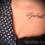 Фото татуировки с именем 'Lyudmila' на теле. Черный контур, каллиграфический шрифт, нанесена на область бедра.