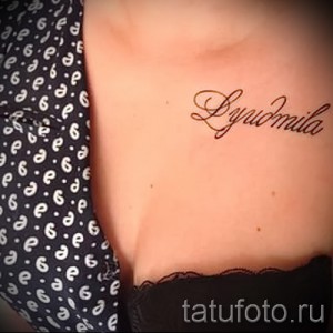 Фото татуировки с именем 'Lyudmila' на теле. Черный контур, каллиграфический шрифт, нанесена на область бедра.