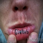 Фото тату надписи 'Cletus' на нижней губе. Черные чернила, простой шрифт, провокационный и необычный дизайн. Подходит для тех, кто не боится экспериментировать.