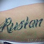 Фото тату надписи 'Rustam' на руке. Черные чернила, каллиграфический шрифт, классический дизайн. Подходит для тех, кто ценит традиционные татуировки.
