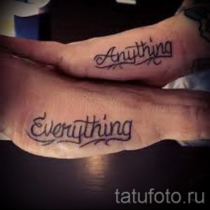 Фото парных татуировок с надписями 'Anything' и 'Everything', выполненными черными чернилами на пальцах рук.