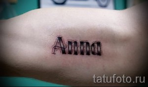 Фото тату на запястье: надпись 'Anna' черным цветом, выполненная в классическом стиле. Минималистичный дизайн, женственный стиль, простой и элегантный.