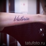 Фото тату с надписью 'Victoria' на запястье. Черные чернила, каллиграфический шрифт, минималистичный дизайн. Идеально для поклонниц именных татуировок.