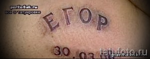 Фото тату надписи 'Егор' и даты '30.03' на груди. Черно-серая татуировка, выполненная в классическом стиле.