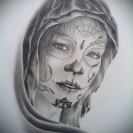 Черно-белый эскиз татуировки с изображением девушки в капюшоне, украшенной мистическими символами и узорами. Рисунок выполнен в реалистичном стиле.