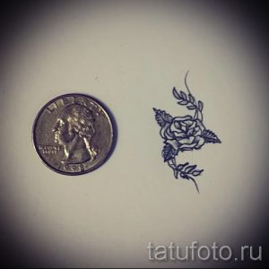 Маленький эскиз татуировки с изображением розы и листьев. Рисунок выполнен в тонких линиях и предназначен для небольшого участка тела.