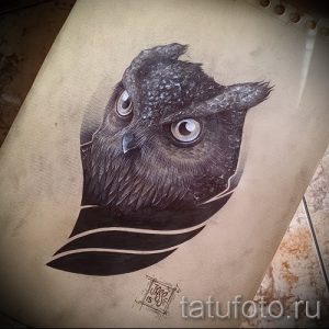 Фотография реалистичной татуировки совы на руке, выполненной в черно-серых тонах. Детализированное изображение с проработкой перьев и глаз.