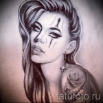 Черно-белый эскиз татуировки с изображением клоунессы с грустным выражением лица и розой на плече. Детализированный рисунок в стиле чикано.