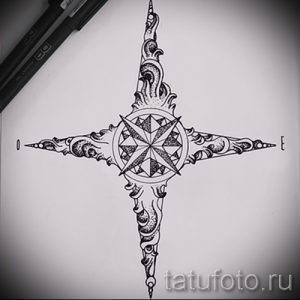 Фото эскиза татуировки компаса, выполненного в минималистичном стиле с использованием тонких линий и геометрических фигур. Рисунок выглядит изящно и современно.