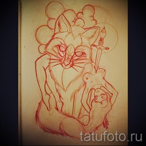 Фото эскиза татуировки лисы с изображением кинжала и женской фигуры. Рисунок выполнен в красноватых тонах и выглядит загадочно.