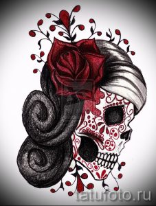 Фото тату: женский череп в стиле сахарной смерти (sugar skull) с розой, локонами и цветочными элементами. Детализированный и красочный рисунок татуировки.