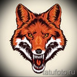 Фото тату головы лиса в классическом стиле. Оранжевая шерсть, желтые глаза, четкие контуры.