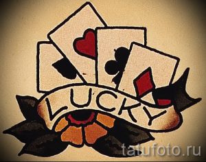 Фото тату: четыре игральные карты и надпись "Lucky" в традиционном стиле олд скул. Яркий и удачливый рисунок татуировки.