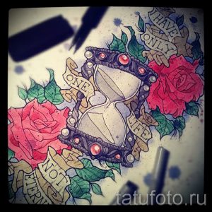Фото тату эскиза с песочными часами, украшенными розами и лентами с надписями. Использованы яркие цвета и детализированная прорисовка.