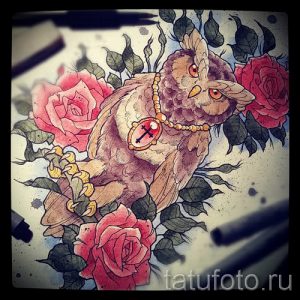 Фото тату эскиза с изображением совы, сидящей среди роз, украшенной бусами и крестом. Детализированная проработка и использование теней.