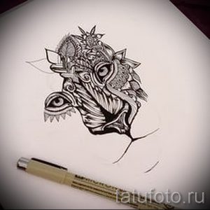 Фото тату: абстрактный рисунок головы тигра, выполненный в технике графики. Идеально для тех, кто ищет оригинальный и необычный дизайн.