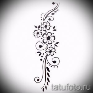 Черно-белый эскиз татуировки с изображением нескольких небольших цветков и листьев, соединенных изящными линиями.