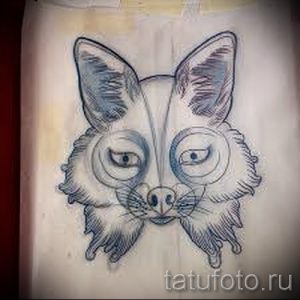 Черно-белое фото эскиза татуировки головы лисенка с большими глазами и пушистой шерстью. Милый и очаровательный рисунок.