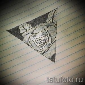Эскиз татуировки с изображением розы, заключенной в треугольник. Геометрический и стильный рисунок в черно-белой гамме.