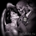 Фото тату в стиле чикано: ангел с крыльями обнимает скелета в костюме. Детализированный черно-серый рисунок с реалистичными тенями.