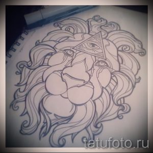 Черно-белый эскиз татуировки льва с треугольником и всевидящим глазом на лбу. Рисунок выполнен в графической манере, с акцентом на детализацию гривы и морды.