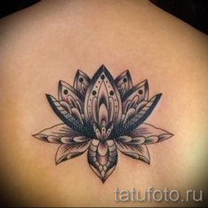 Фото тату лотоса на спине. Черно-белый рисунок в стиле дотворк с геометрическими узорами. Идеи для минималистичных тату.