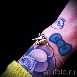Фото тату: Голубой бантик и роза на запястье. Красивый рисунок татуировки с яркими цветами и детальной проработкой.