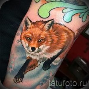 Фото реалистичной татуировки лисы, лежащей на руке, с детально прорисованной шерстью и выразительными глазами.