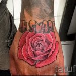 Фото тату: красная роза с надписью "Love" на руке. Реалистичный рисунок, цветочная тематика, символ любви.