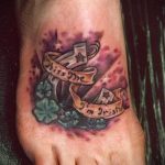 Фото тату надписи "Kiss Me I'm Irish" и клевера на стопе. Цветная татуировка с использованием акварельной техники.