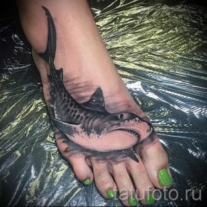 Фото тату: реалистичное изображение акулы, выполненное на стопе. Детализированная проработка чешуи, плавников и зубов.