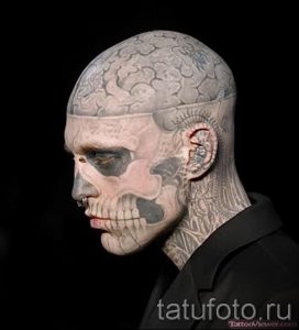 Фото экстремальной татуировки, покрывающей голову и лицо человека, имитирующей череп.