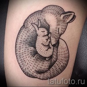Фото татуировки лисы, обнимающей зайчика, выполненной в технике дотворк. Нежный рисунок татуировки на руке.