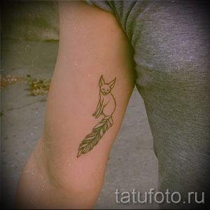 Фото простой татуировки лисы в профиль, выполненной тонкими коричневыми линиями. Небольшой рисунок татуировки на руке.