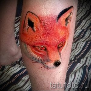 Фото тату головы лисы на руке, выполненное в ярком и красочном стиле с использованием акварельных техник.