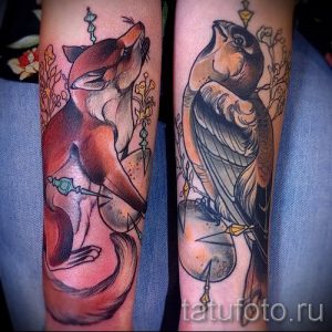 Фото тату лисы и птицы на руке в стиле олдскул, с использованием ярких цветов и четких контуров.