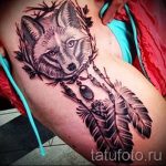 Фото тату лисы в стиле графика с ловцом снов, выполненное в черно-серых тонах на руке.