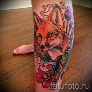Татуировка лисы, курящей трубку, с маками на руке. Рисунок выполнен в ярких цветах с использованием традиционной татуировочной техники.