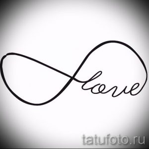 Фото татуировки в виде символа бесконечности, внутри которого написано слово 'Love' изящным рукописным шрифтом. Нежный и романтичный дизайн.
