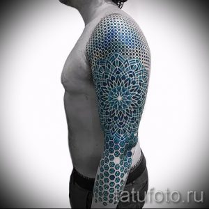Фото тату мандалы на руке. Цветной рисунок татуировки в стиле геометрия с использованием синих и белых оттенков. Детализированный и эффектный дизайн.