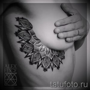 Фото тату мандалы на груди. Черно-белый рисунок с детальной проработкой узоров и точками. Оригинальный эскиз тату для девушек.