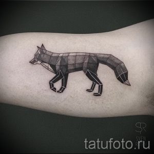 Фото тату лисы на предплечье, выполненное в геометрическом стиле. Рисунок татуировки состоит из множества треугольников и линий.