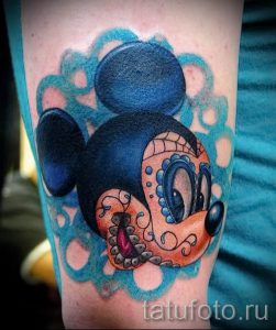 Фото тату на предплечье с изображением Микки Мауса в стиле Sugar Skull. Яркие цвета, детализированный рисунок и необычный дизайн.