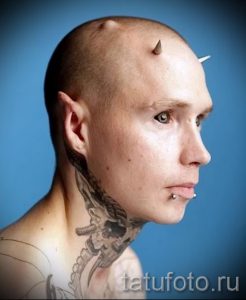 Фото тату: татуировка на шее в стиле биомеханика, импланты на голове, экстремальная модификация тела, необычный и провокационный рисунок.