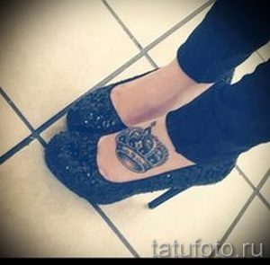 Фото татуировки на лодыжке с изображением короны. Рисунок выполнен в черно-белой гамме с использованием штриховки и теней.