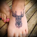Фото татуировки на лодыжке с изображением головы оленя. Рисунок выполнен в минималистичном стиле, черно-белой гамме.