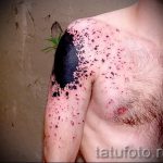 Фото тату на плече и груди с изображением черных брызг и пятен. Абстрактный рисунок.