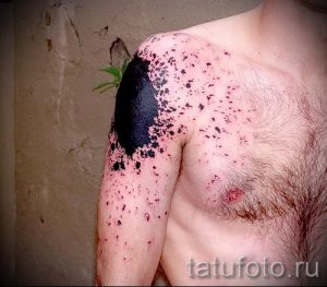 Фото тату на плече и груди с изображением черных брызг и пятен. Абстрактный рисунок.