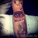 Фото тату на руке с изображением глаза, надписи 'Believe' и рыцаря в доспехах. Черно-белый рисунок.